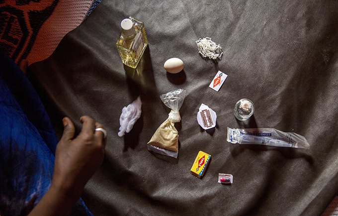 Asha présente les outils qu’elle utilise pour pratiquer les mutilations génitales féminines en Somalie. © UNFPA/Georgina Goodwin