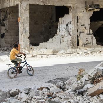 Homs-Syria-September-2013.-Boy-riding-a-bicycle-among-destroyed-houses