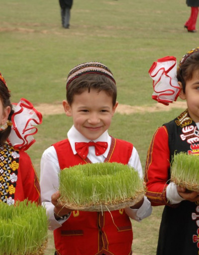 Three children are holding sprouts, symbolizing the beginning of spring
