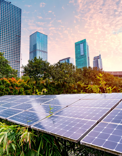 Image features solar panels, greenspace, and skyscrapers in the background.
