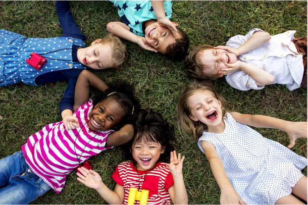 Children smiling lying down on the grass