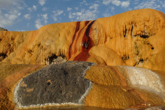 The calcite deposits of Gechi Qalasi spring are particularly colorful, featuring yellow, lemon, red, brown and white. It is one of many travertine springs in Aras UNESCO Global Geopark, Iran. The chemical precipitation of calcium carbonate minerals from these springs forms a sedimentary rock called travertine.