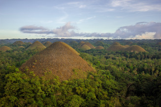 Chocolate Hills in Bohol Island UNESCO Global Geopark, Philippines. This unique karst landscape is composed of smooth, conical hills. They are the result of thousands of years of erosion of the limestone on what was once a thick build-up of coral reefs that thrived during the Pliocene approximately 2-5 million years ago. 