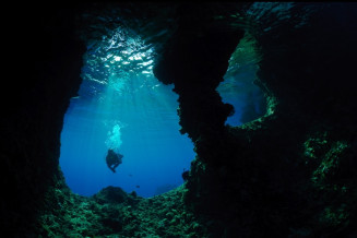 Scuba-divers flock to Raja Ampat UNESCO Global Geopark, drawn by the beauty of the underwater caves and the extraordinary marine mega-biodiversity. Here in Boo Window Underwater Cave, Misool, Indonesia