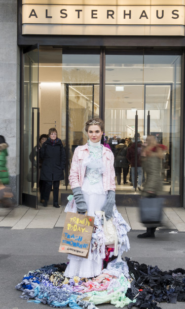 An activist disguised as a Trash Queen promotes “Buy Nothing Day” on Black Friday in Hamburg, Germany, 2016, as part of a Greenpeace campaign to reduce overconsumption.