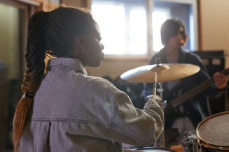 black-young-woman-playing-drums-in-rock-band