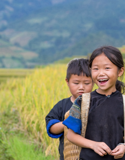 Smiling Vietnamese Hmong children on the rice terrace river, in the district of Mu Cang Chai, Yenbai province, north-west Vietnam.